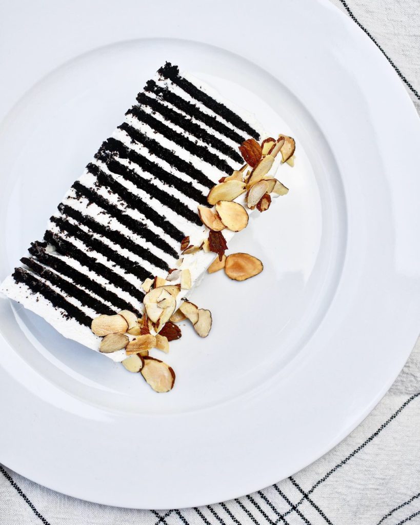 single slice of chocolate wafer cake on a white plate.