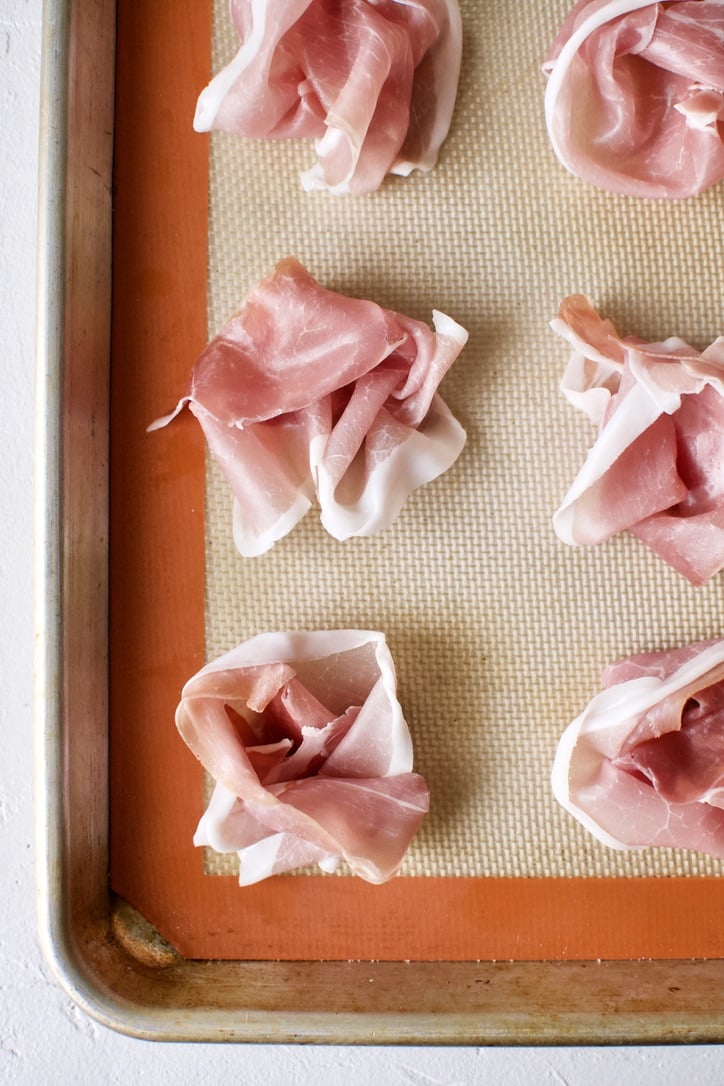 Prosciutto rolled into roses, before baking.