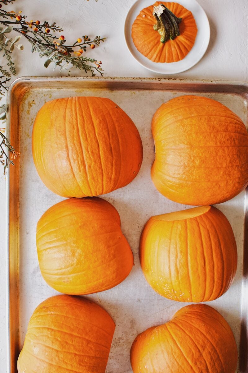 pumpkins that have been halved and on a sheet pan ready to roast.