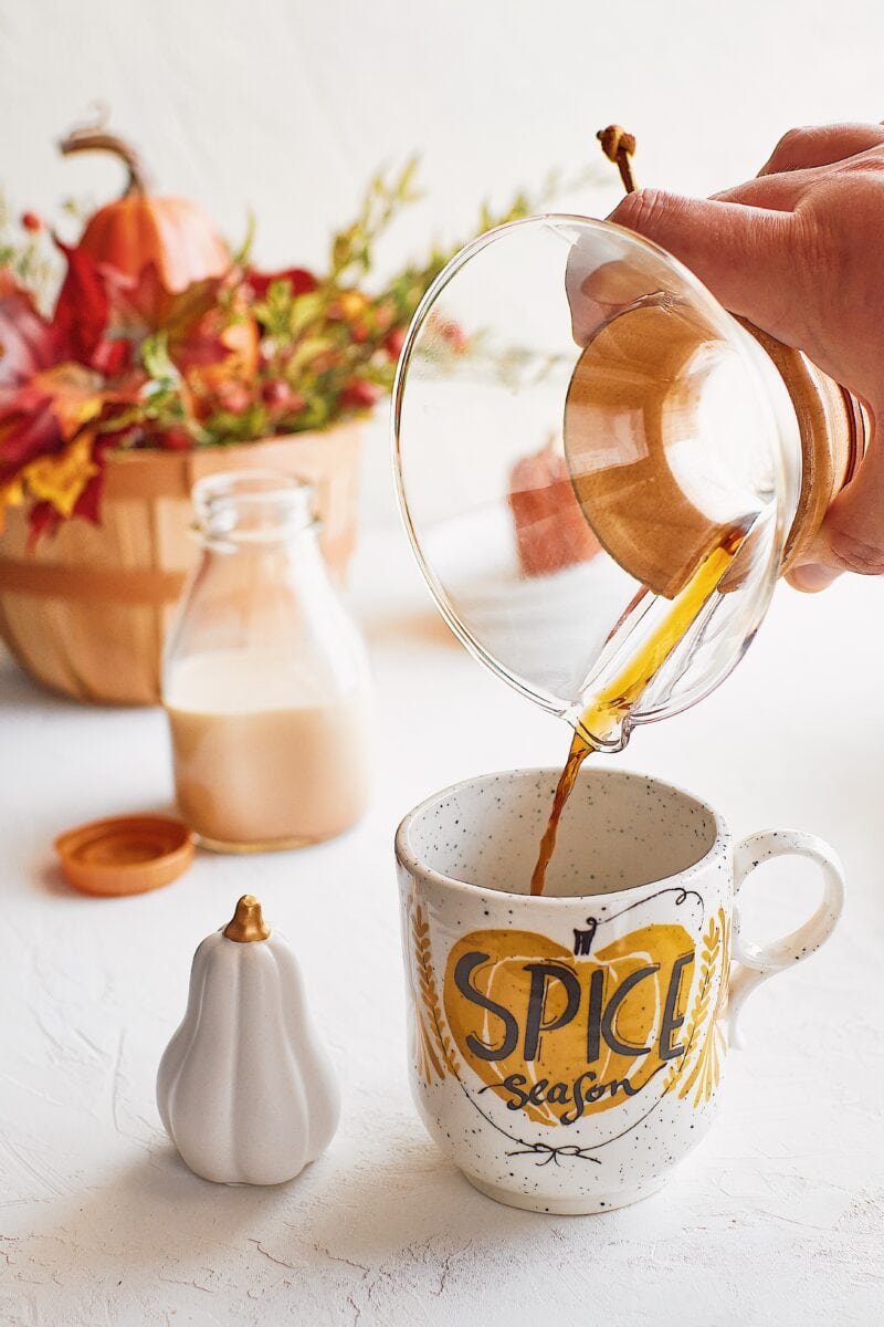 coffee being poured into a cup that says pumpkin spice season