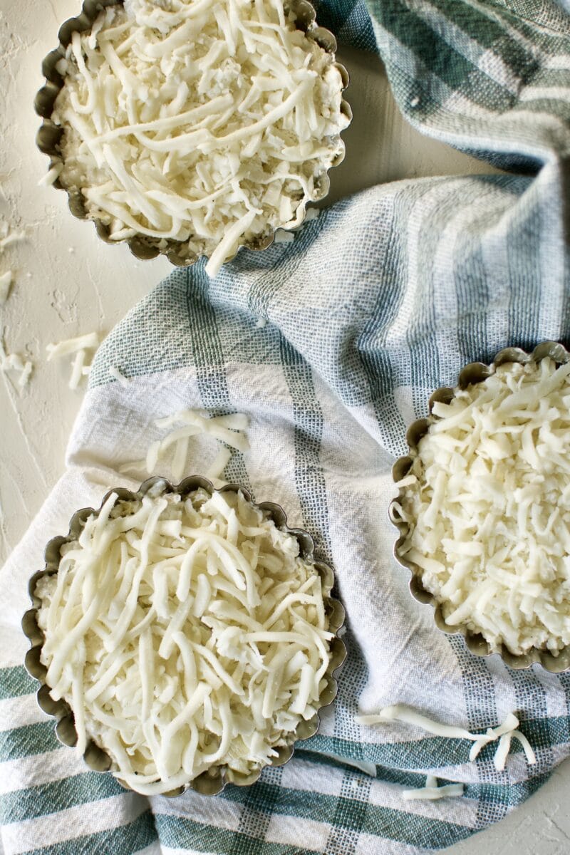 Artichoke Three Cheese Dip, dished into individual bowls for baking.