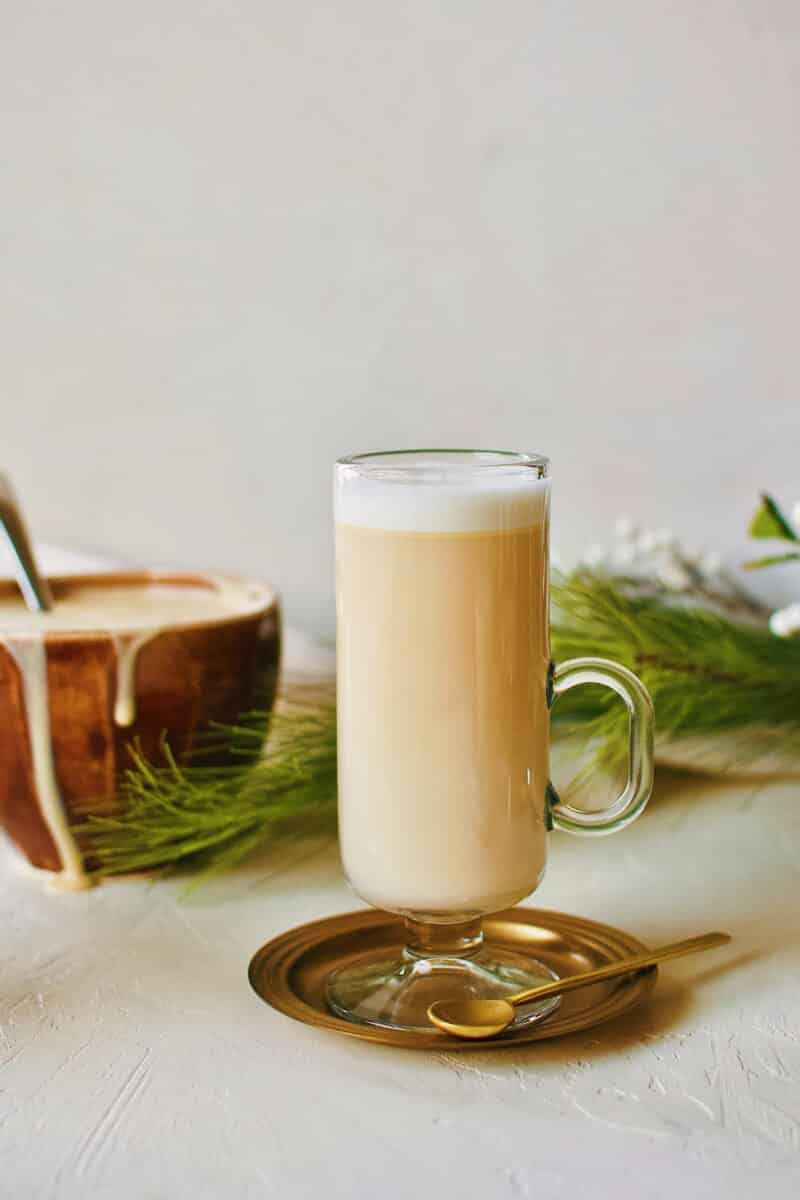 Hot buttered rum on a plate with a spoon.