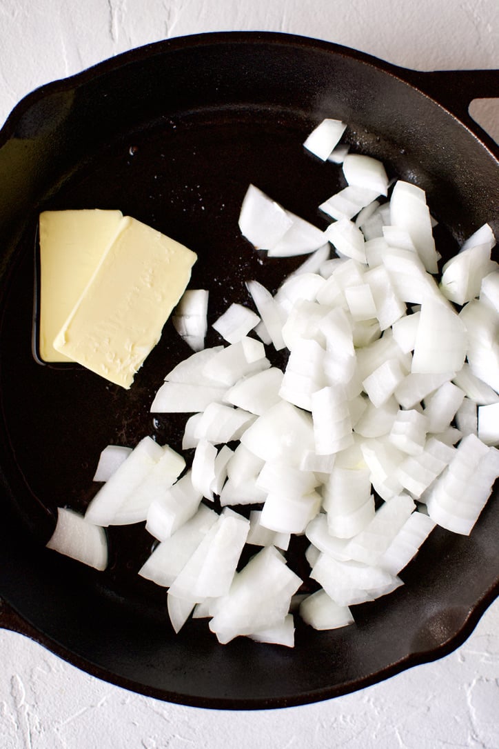 Onions and butter in a cast-iron pan.