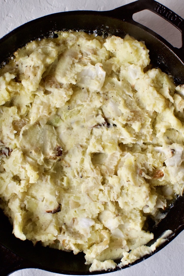 Irish Colcannon Potatoes cooking for the second time in a cast-iron pan.