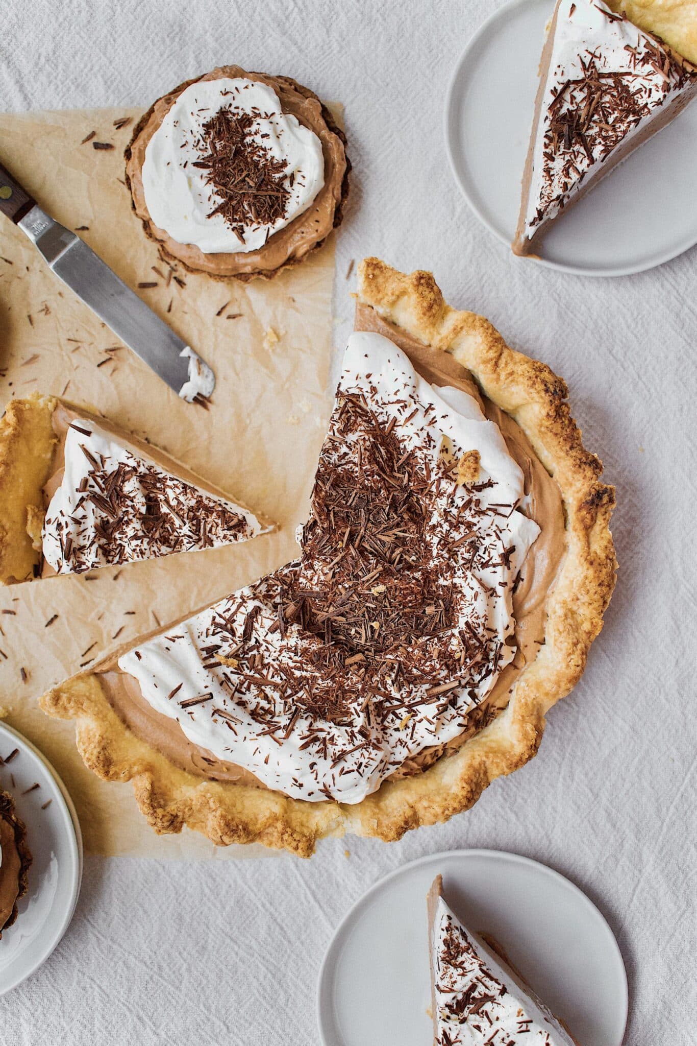 Joanna Gaines French Silk Pie that has been sliced, with tartlets around it