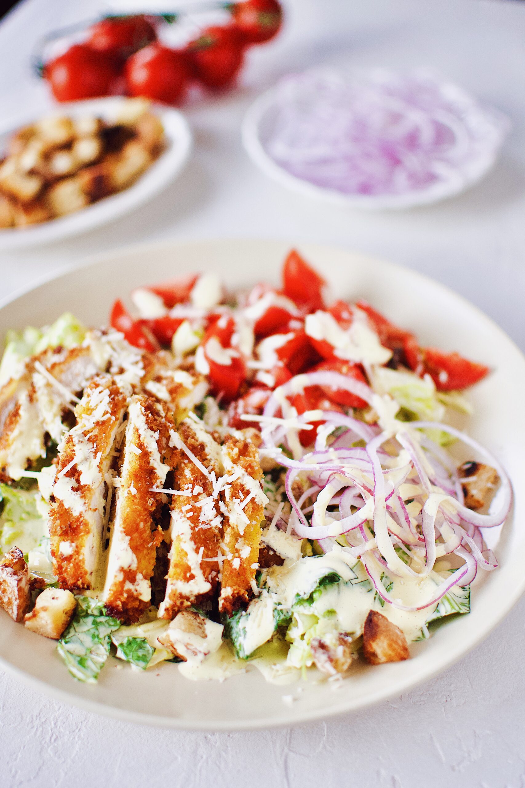 Creamy Caesar Dressing on a Crispy Parmesan Chicken Caesar Salad.