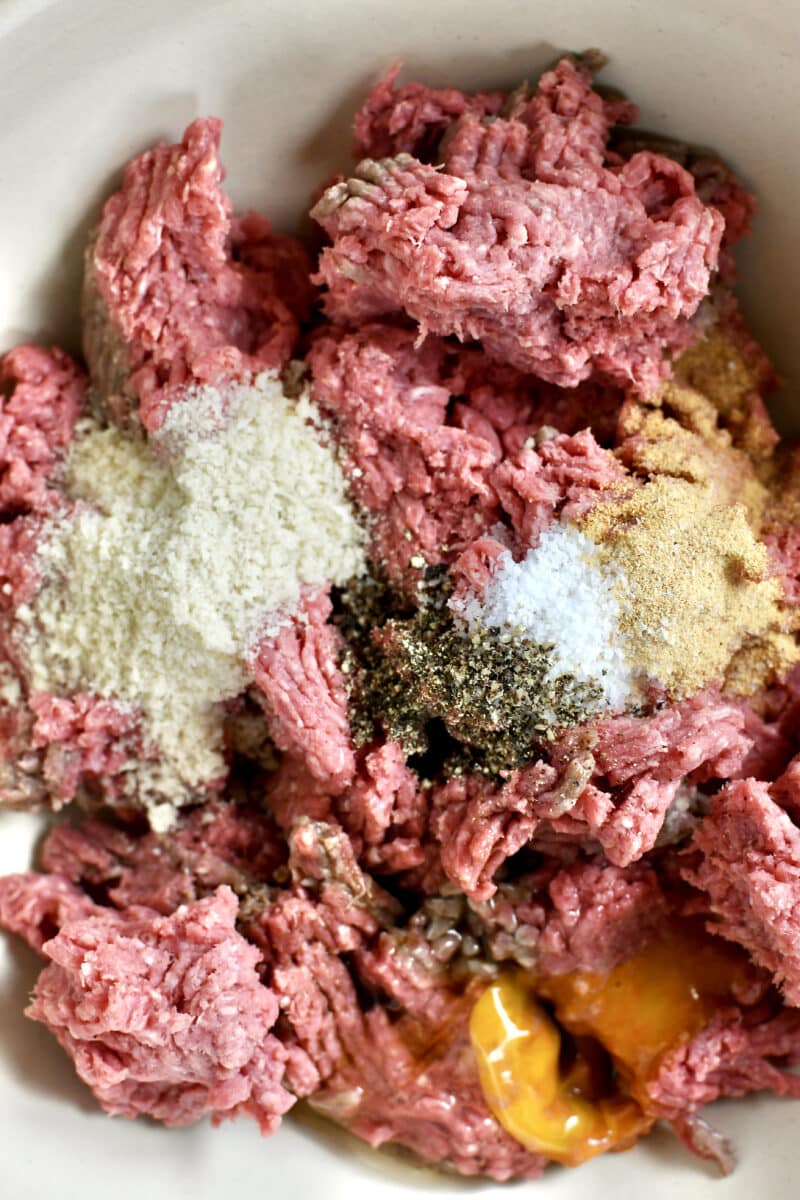 Mixing together the ingredients to make Not-So "Basic" Burgers in a large bowl.