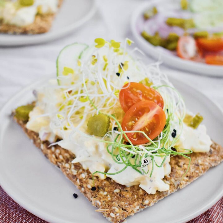 Nordic Egg Salad ready to eat, on a nut cracker and on a white plate.