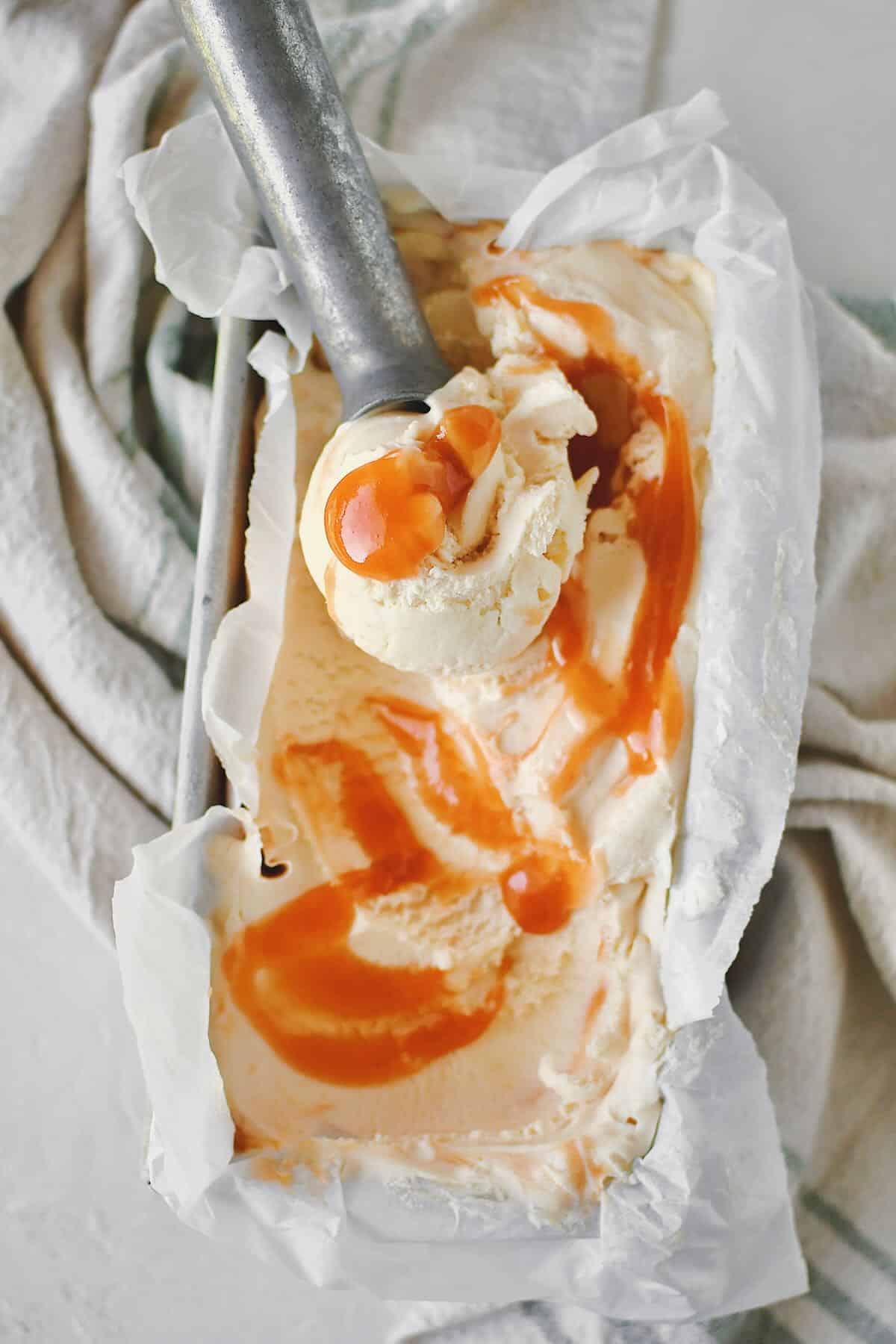 Peach Ice Cream being scooped out of a container.