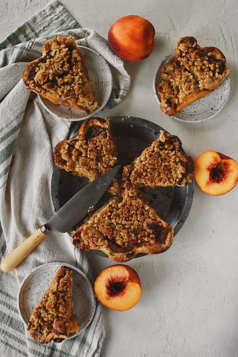 Looking down at a sliced spiced peach pie, ready to be eaten.