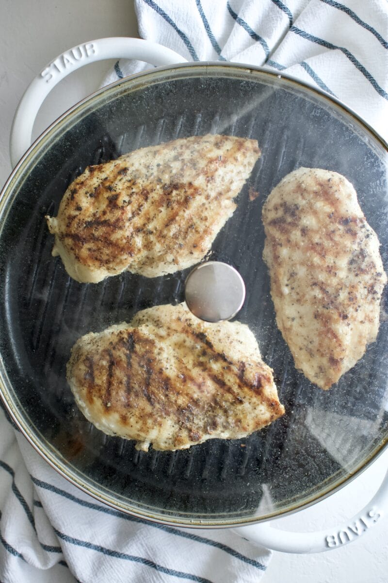 grill with lid on and chicken steaming inside