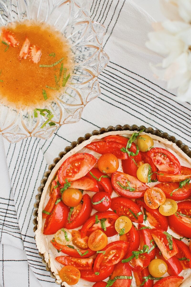 tomatoes being placed in the tart shell