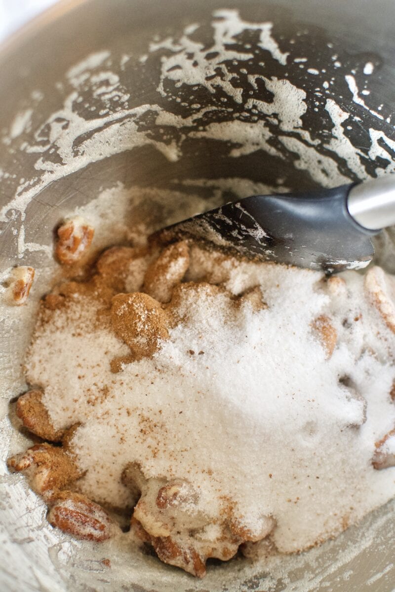 Sugar, salt, and spices being added to the coated pecans