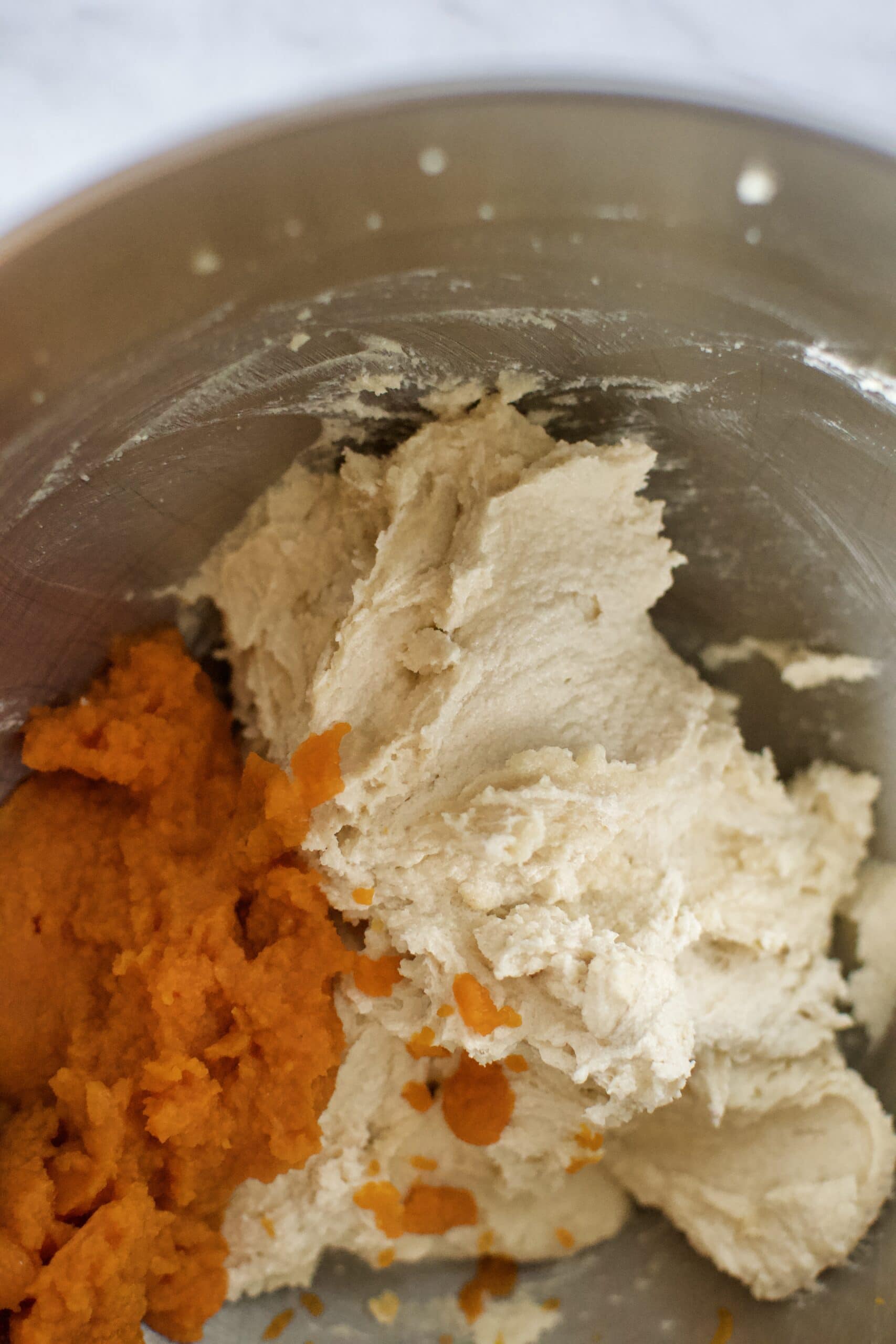 Whipped butter and sugar adding pumpkin in to the cookie dough