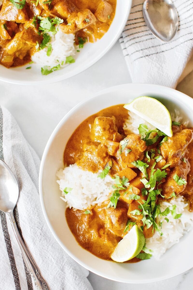Pumpkin Butter Chicken recipe served with basmati rice, cilantro, and lime wedges.