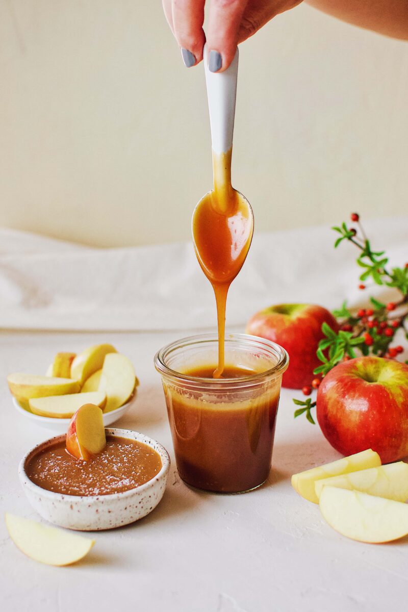 Homemade Caramel Sauce with apples for dipping. Dripping from a spoon.