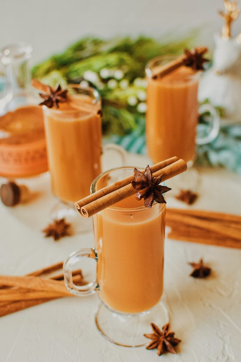 3 Winter Whiskey Wassail garnished with a cinnamon stick and star anise pod.