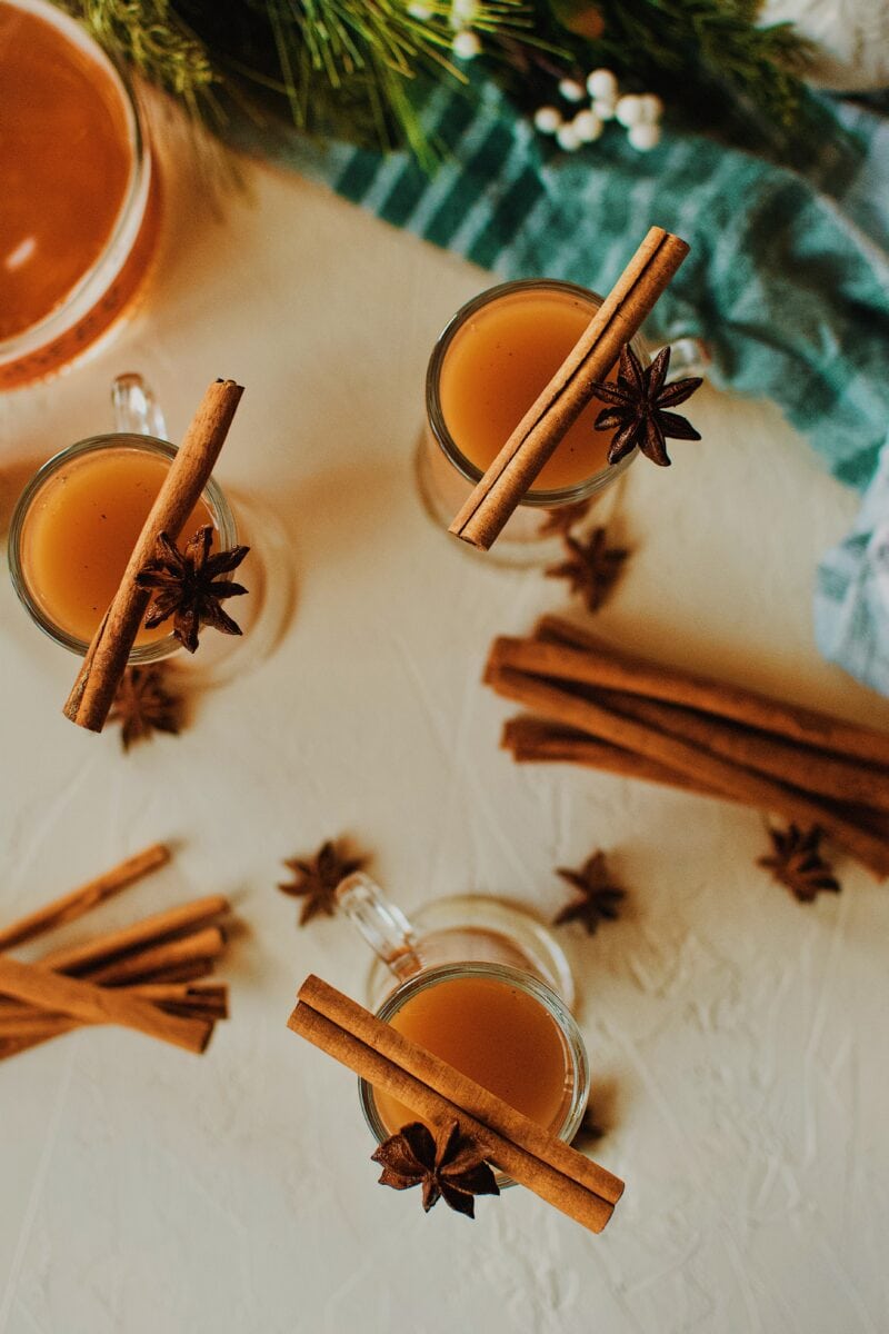 3 Winter Whiskey Wassail garnished with a cinnamon stick and star anise pod.