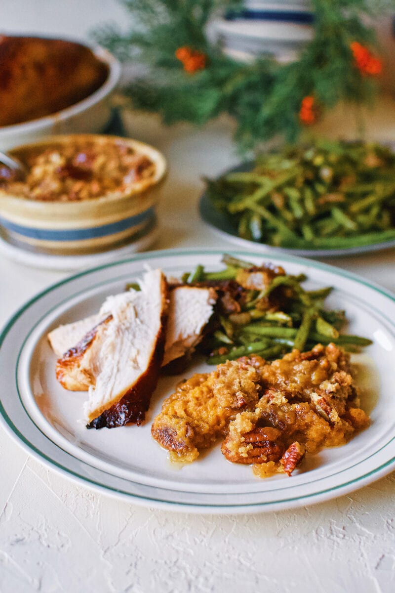 Great Aunt Sally's Sweet Potato Soufflé on a plate with Thanksgiving turkey and green beans.