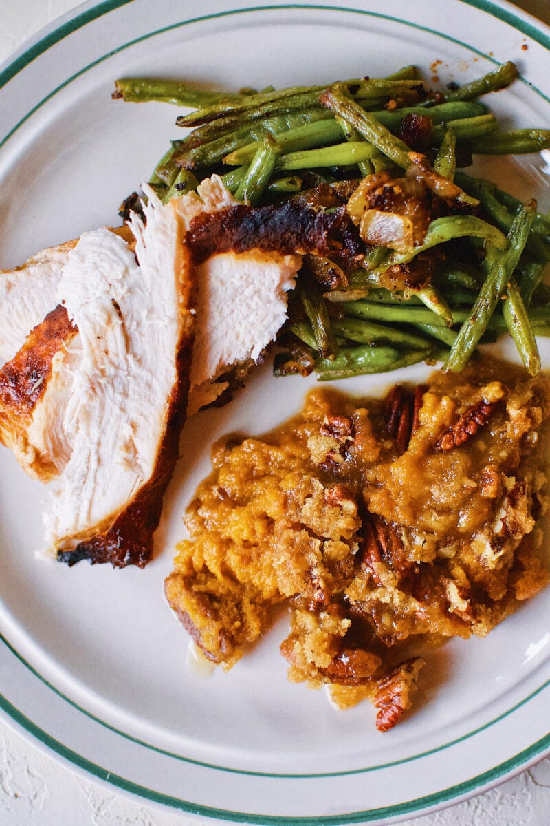 Great Aunt Sally's Sweet Potato Soufflé on a plate with Thanksgiving turkey and green beans.