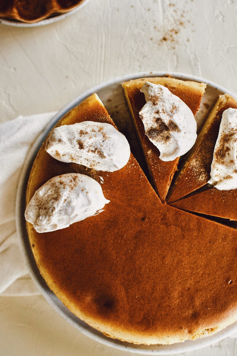 Chai-Spiced Cheesecake sliced and topped with Chai-Spiced Whipped Cream.