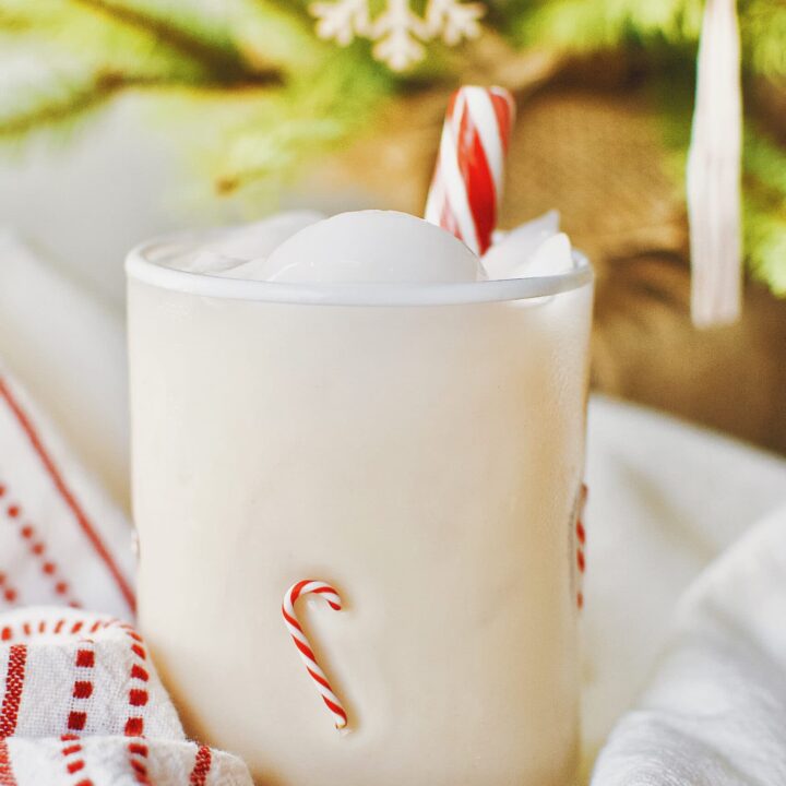 Peppermint Chai Eggnog Cocktail nestled under a Christmas tree.