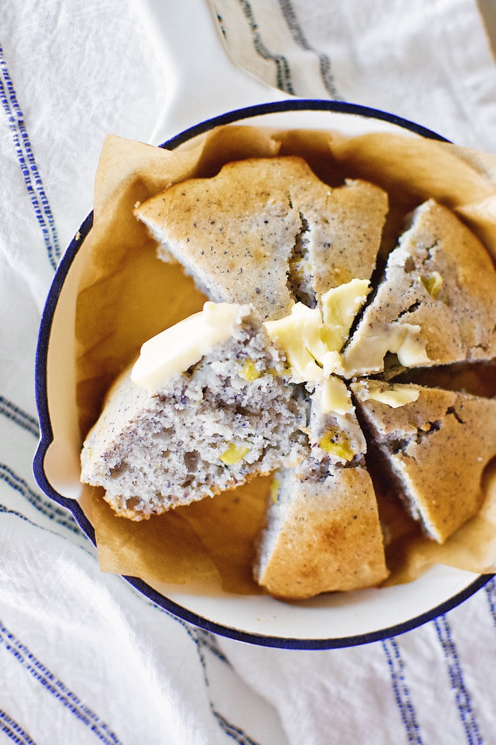 Blue Cornbread in a skillet with butter spread on top.