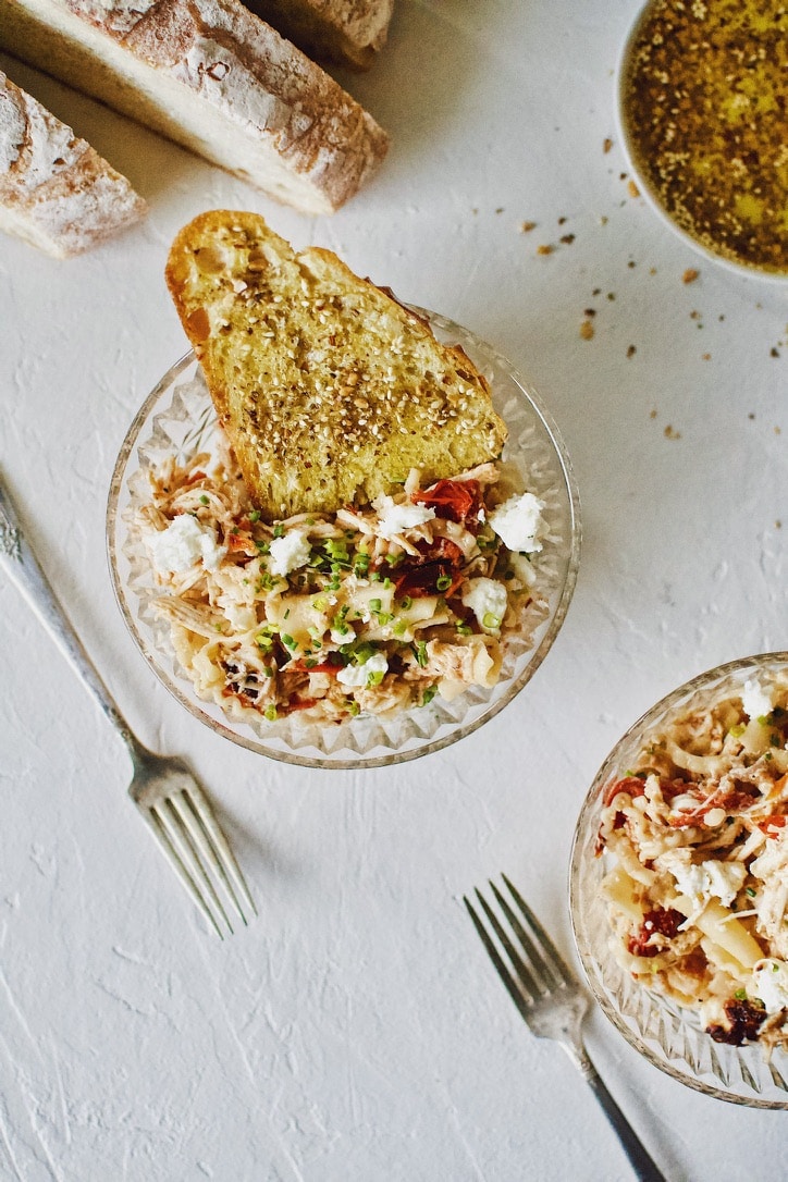 Baked Feta Pasta with Chicken served in bowls with crust bread dipped in olive oil.