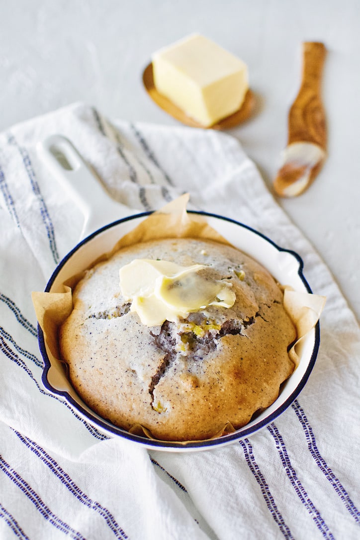 Blue Cornbread in a skillet with butter spread on top.