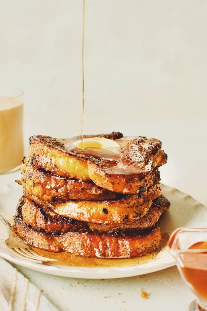 Finished French Toast sprinkled with cinnamon sugar, topped with butter, and drizzled with maple syrup.