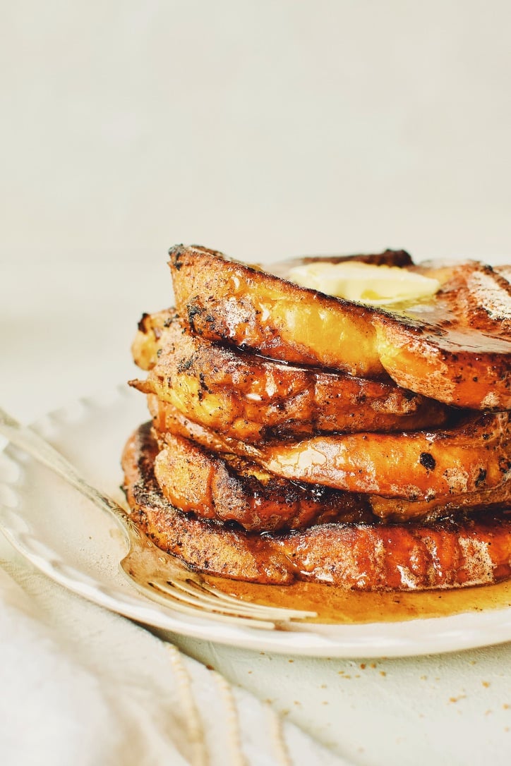 Finished French Toast sprinkled with cinnamon sugar, topped with butter, and drizzled with maple syrup.