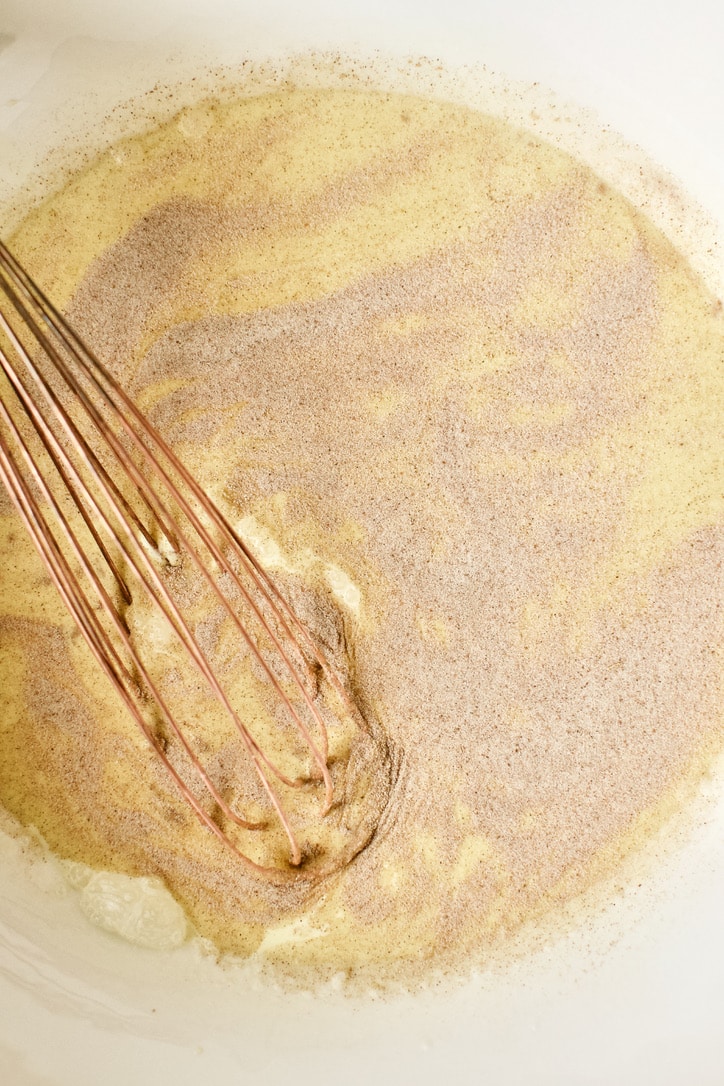 Whipping the egg yolks, cream, half and half, and vanilla together in a bowl with some cinnamon sugar.