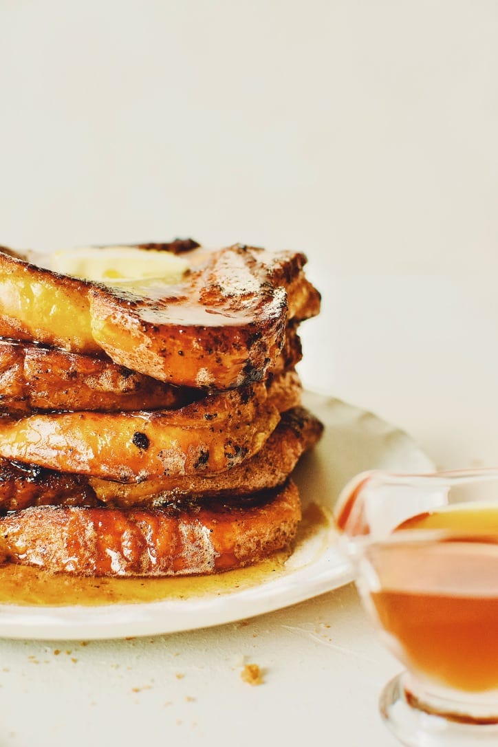 Finished French Toast sprinkled with cinnamon sugar, topped with butter, and drizzled with maple syrup.