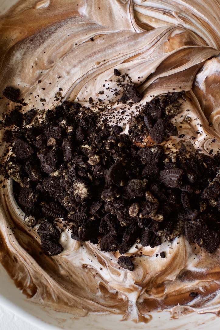 Folding together the chocolate pudding and whipped topping with some of the crushed cookies.