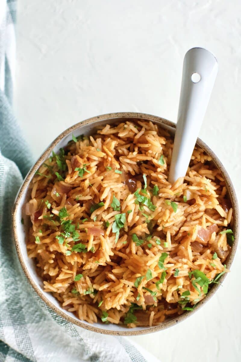 Weta Rice in a serving bowl, topped with Cilantro, and and spoon in the bowl.