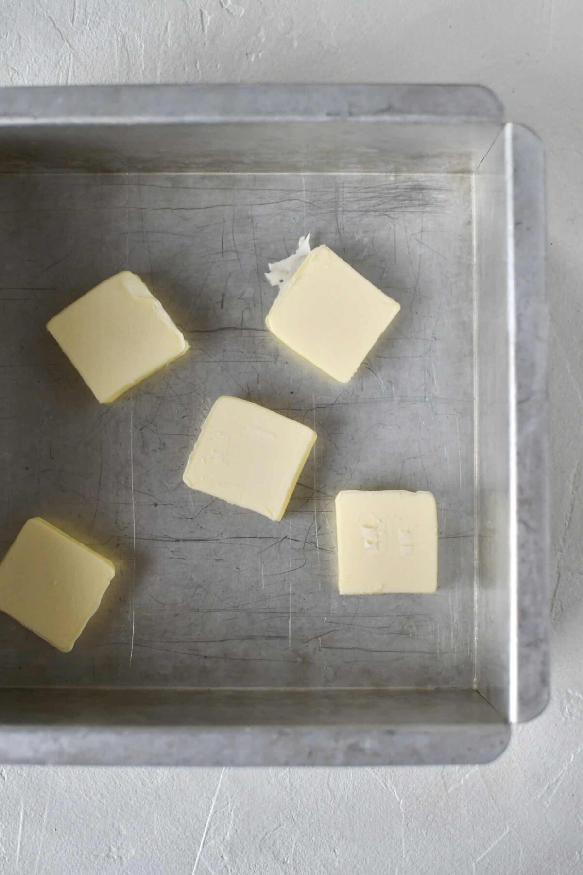 Butter in the bottom of an 8x8 metal baking tin.