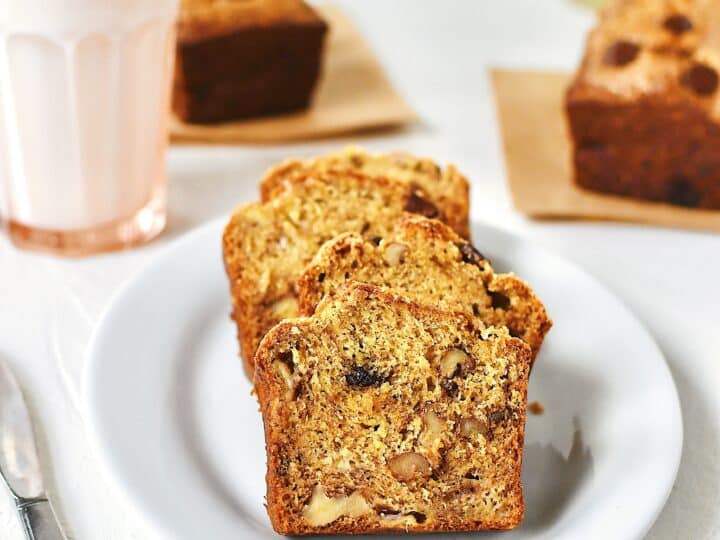 Slices of banana bread on a plate with a glass of milk nearby.