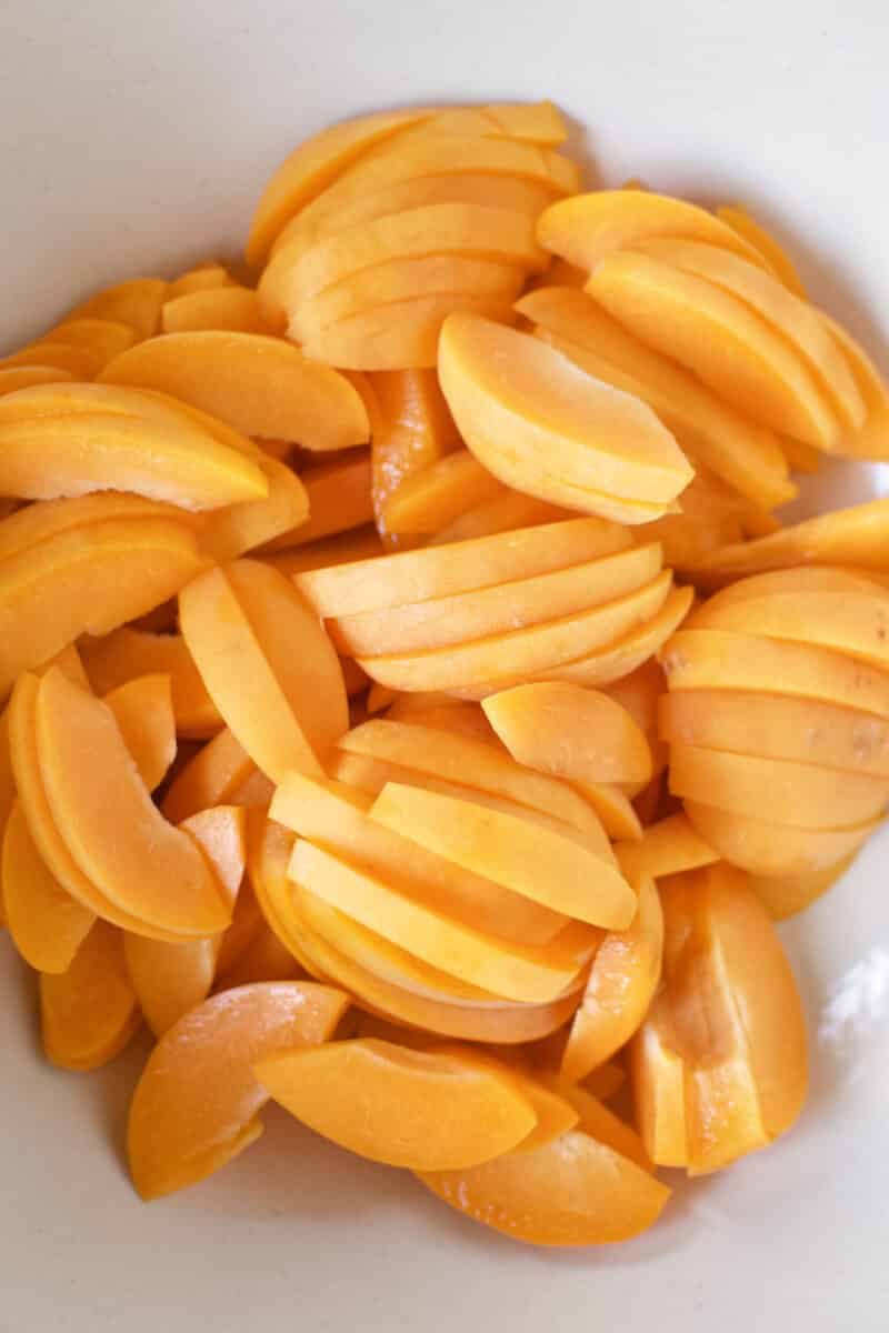 Fresh apricots sliced and placed in a large bowl.