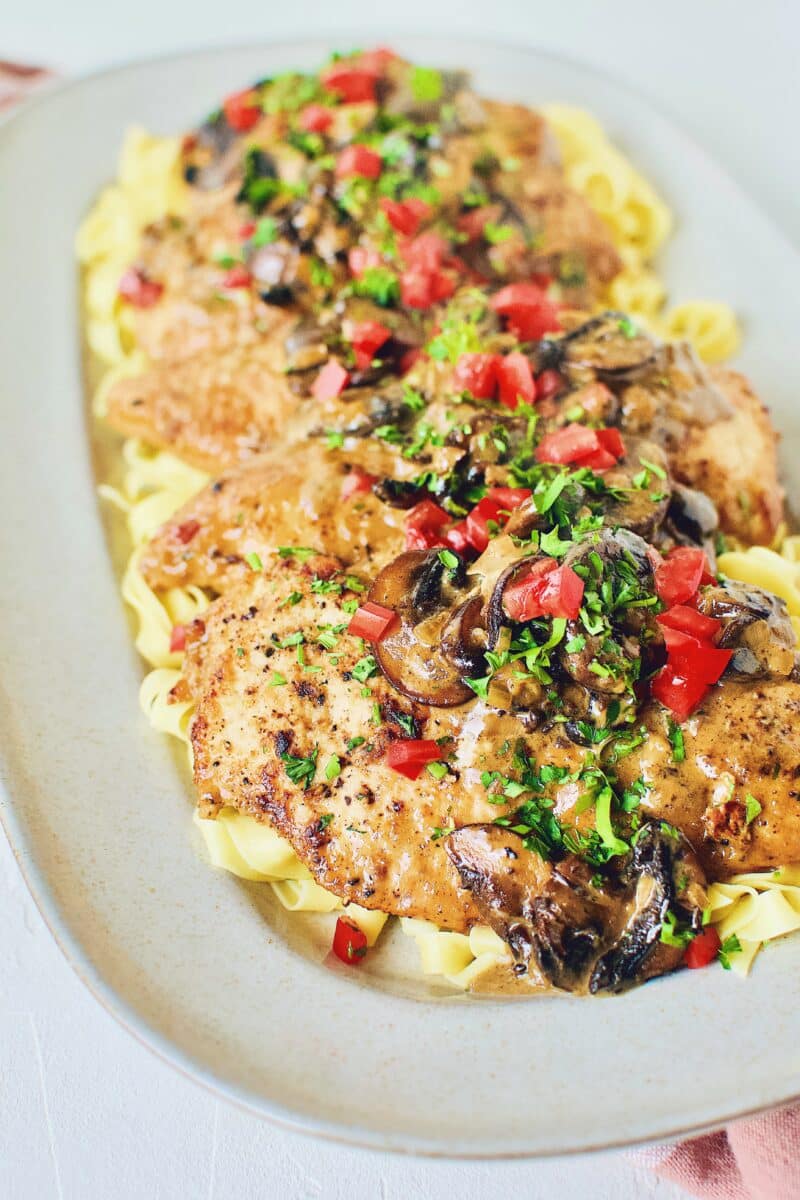 Creamy Chicken and Mushrooms served on a bed of fresh homemade pasta.