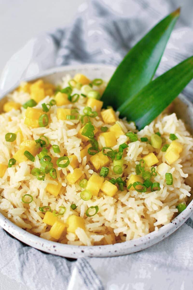 Pineapple Coconut Rice in a bowl topped with diced pineapple and green onions.