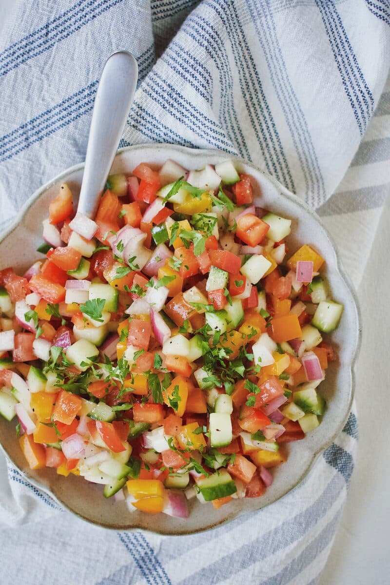 Greek Pico de Gallo in a bowl with a spoon.