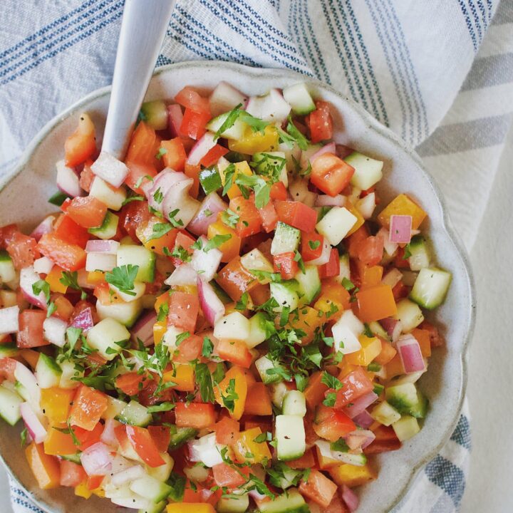 Greek Pico de Gallo in a bowl with a spoon.