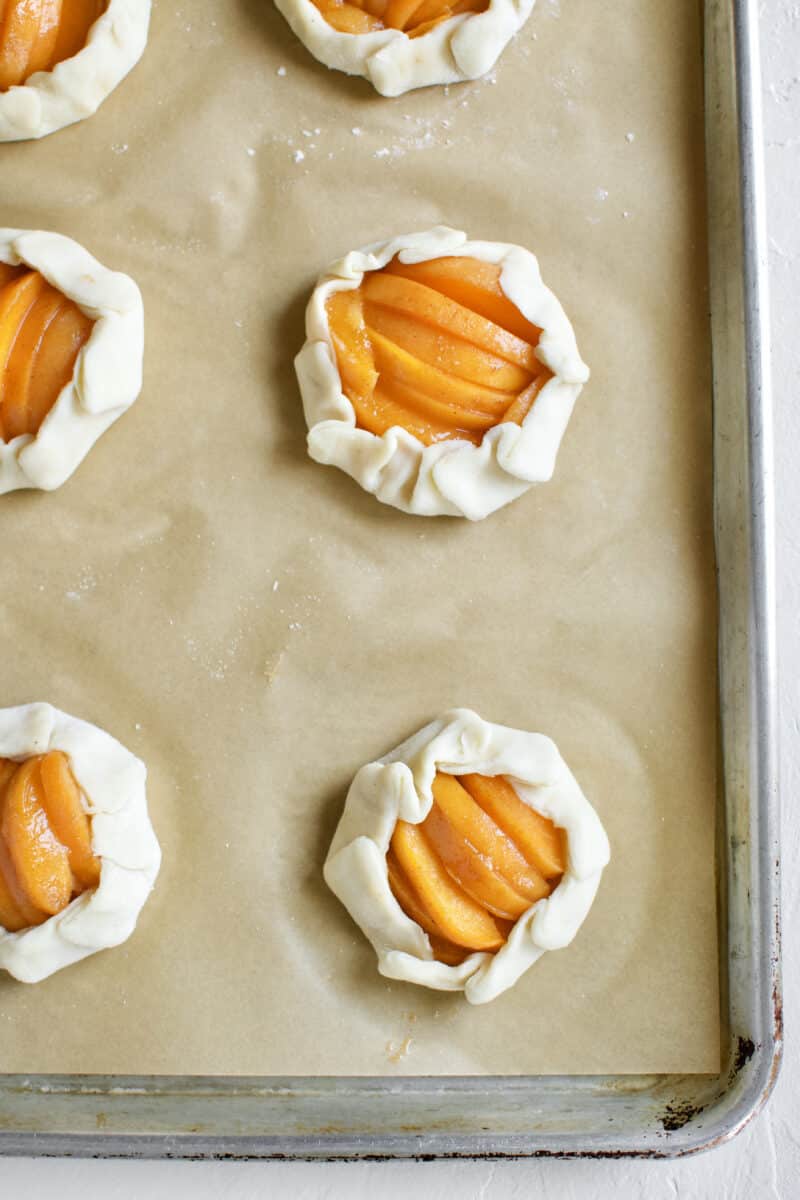 Fully formed Apricot Pie, mini pies with pie dough crimped around the outside of apricot slices.