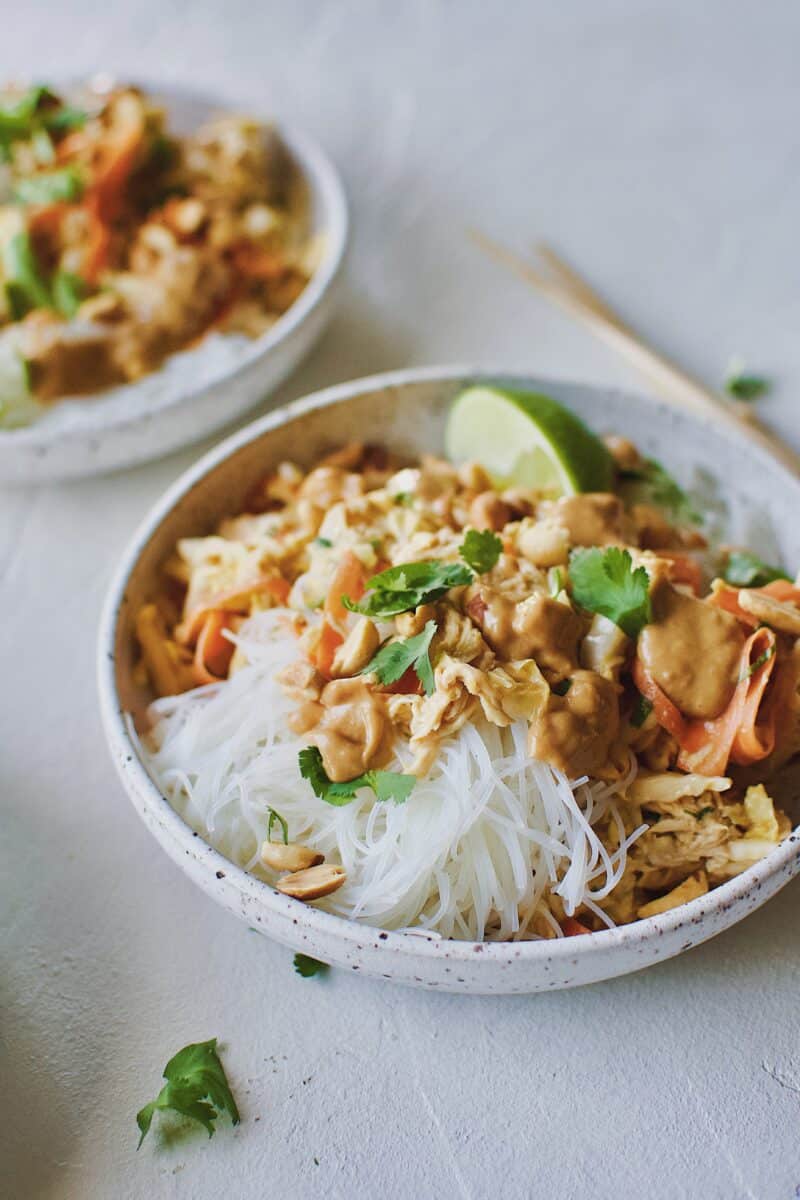 Asian Noodle Salad with Chicken in a noodle bowl and chopsticks on the side.