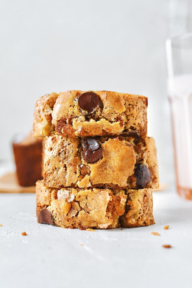 Slices of banana bread on a plate with a glass of milk nearby.