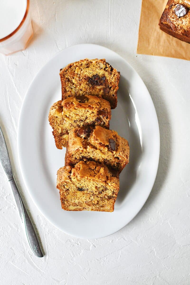 Slices of banana bread on a plate with a glass of milk nearby.