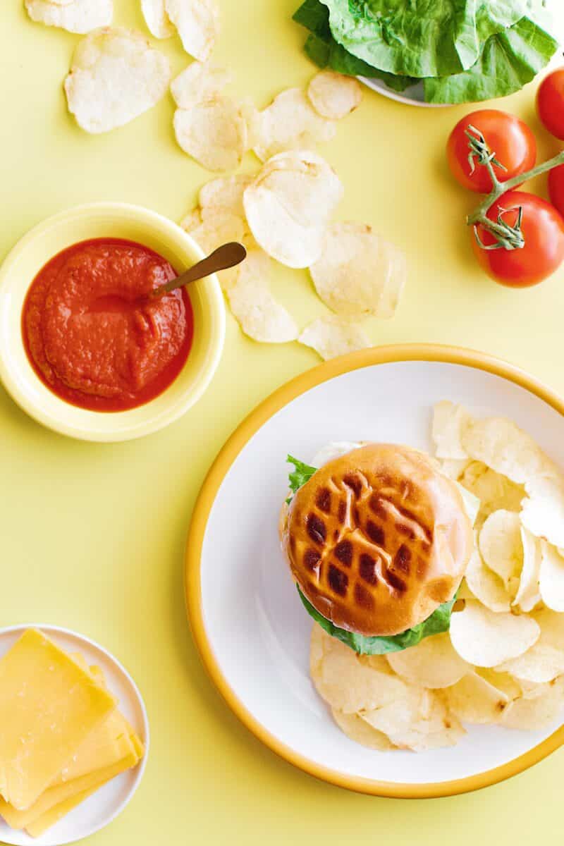 Not-So "Basic" Burger stacked up on a plate with chips and my favorite toppings.