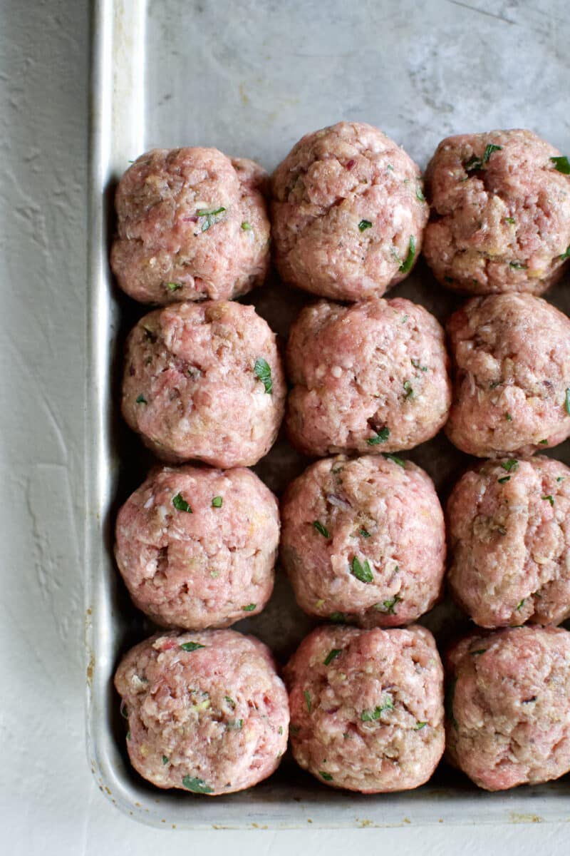 Uniformed meatballs lined up on a tray.