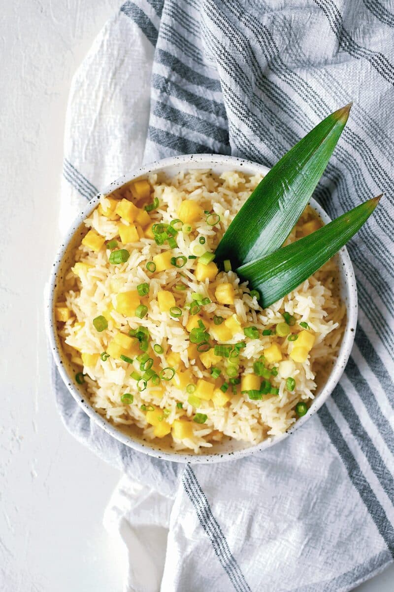 Pineapple Coconut Rice in a bowl topped with diced pineapple and green onions.