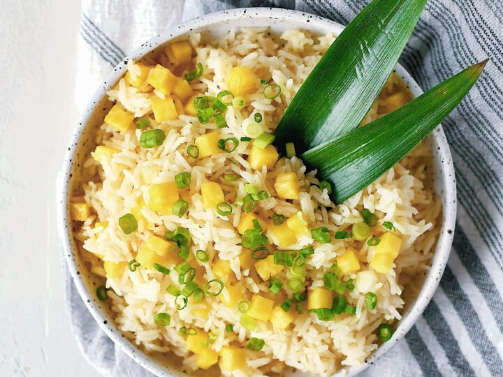 Pineapple Coconut Rice in a bowl topped with diced pineapple and green onions.